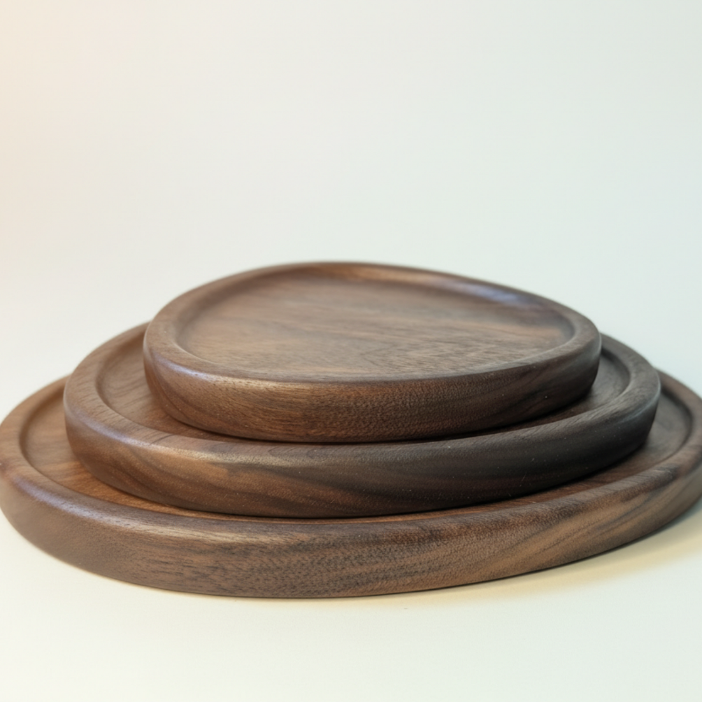 Set of three wooden trays stacked on a light gray background