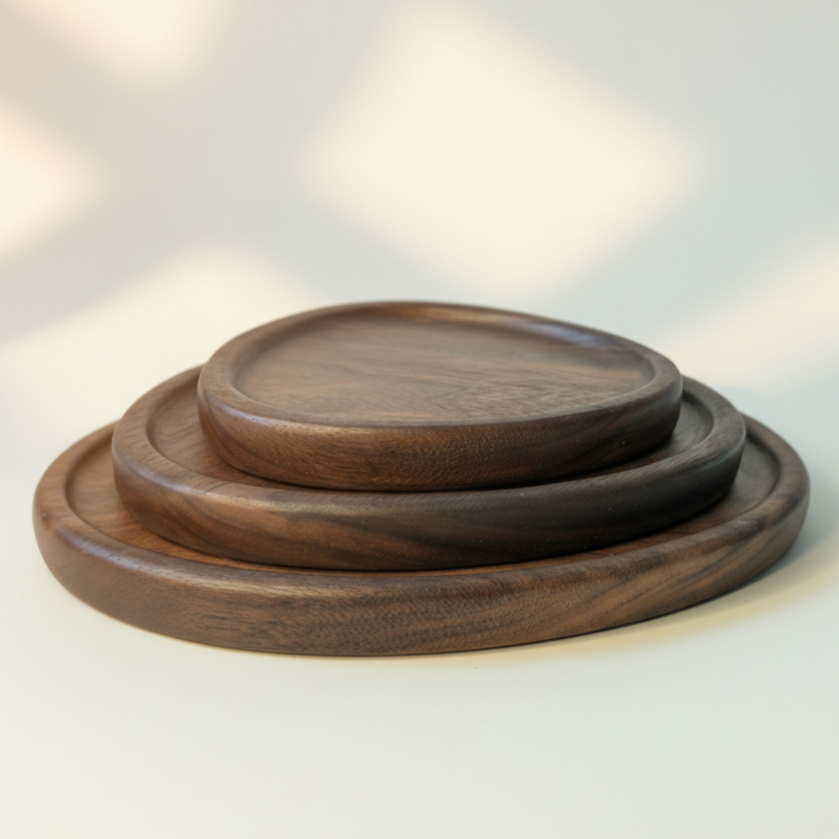 Set of three wooden trays stacked on a light gray background