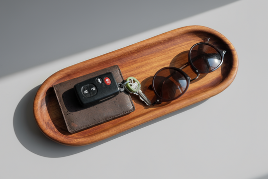 Wooden tray with sunglasses and car keys on a light gray surface