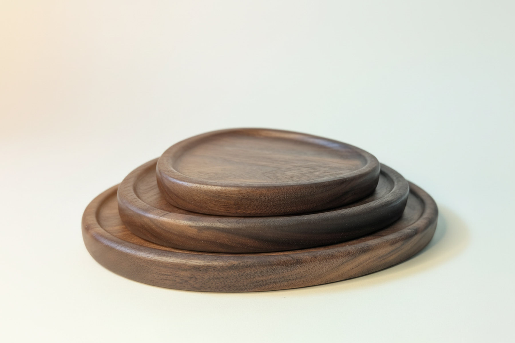 Set of three wooden trays stacked on a light gray background