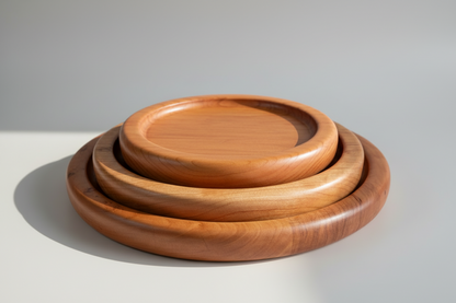 Three wooden trays of different sizes stacked on a light gray background