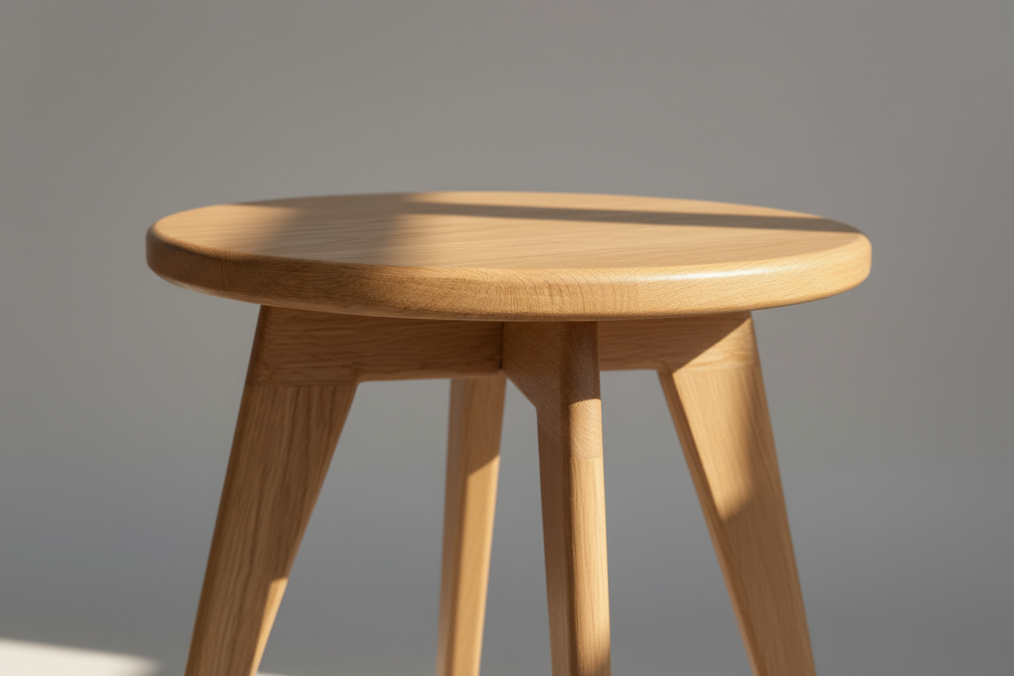 Wooden stool with a round seat on a plain background