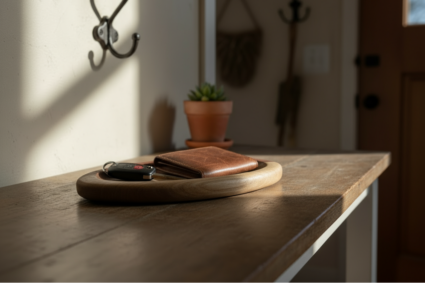 Brown leather wallet and car key on a wooden surface with a blurred background